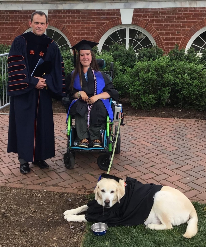 Shea graduating with her service dog, both in their cap & gown